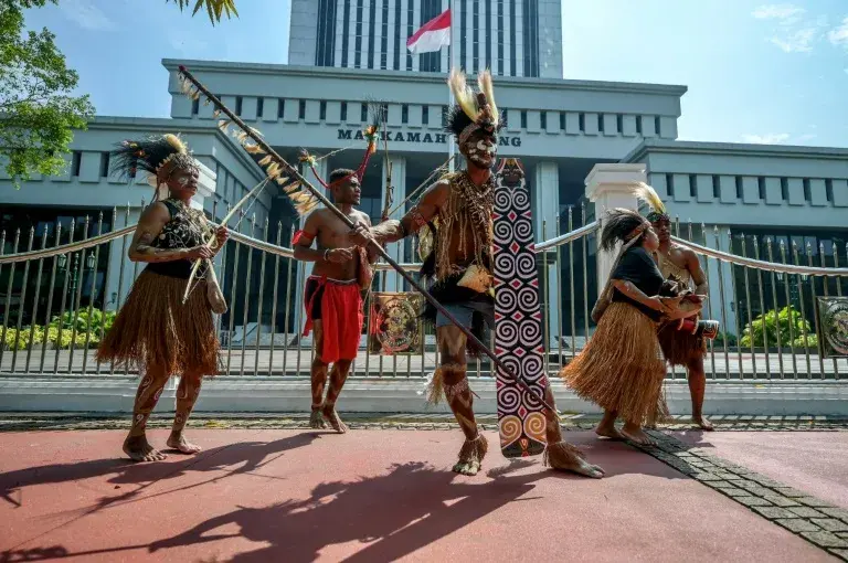 Representatives of the Awyu and Moi Indigenous tribes protest in front of the Indonesian Supreme Court