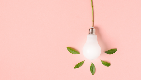 Fonte: Acervo Canva. Uma lâmpada branca com folhas em volta com fundo rosa.