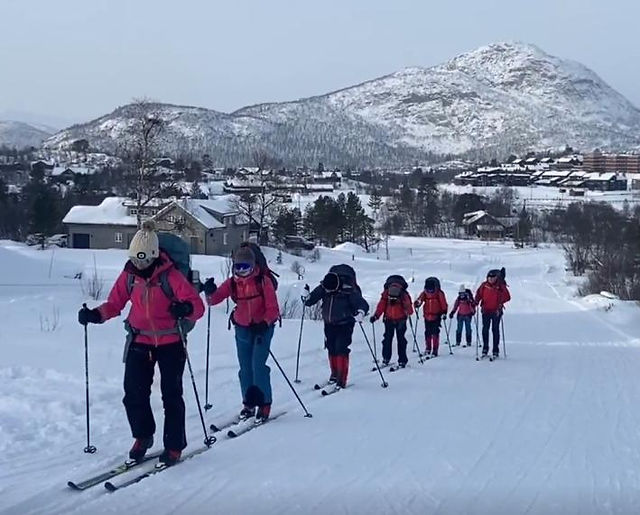 Canford School CCF cadets Nordic ski touring in single file through a snow-covered Norwegian mountain landscape.