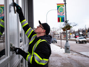A window cleaner using a squeegee to clean the exterior glass of a building during the winter time.