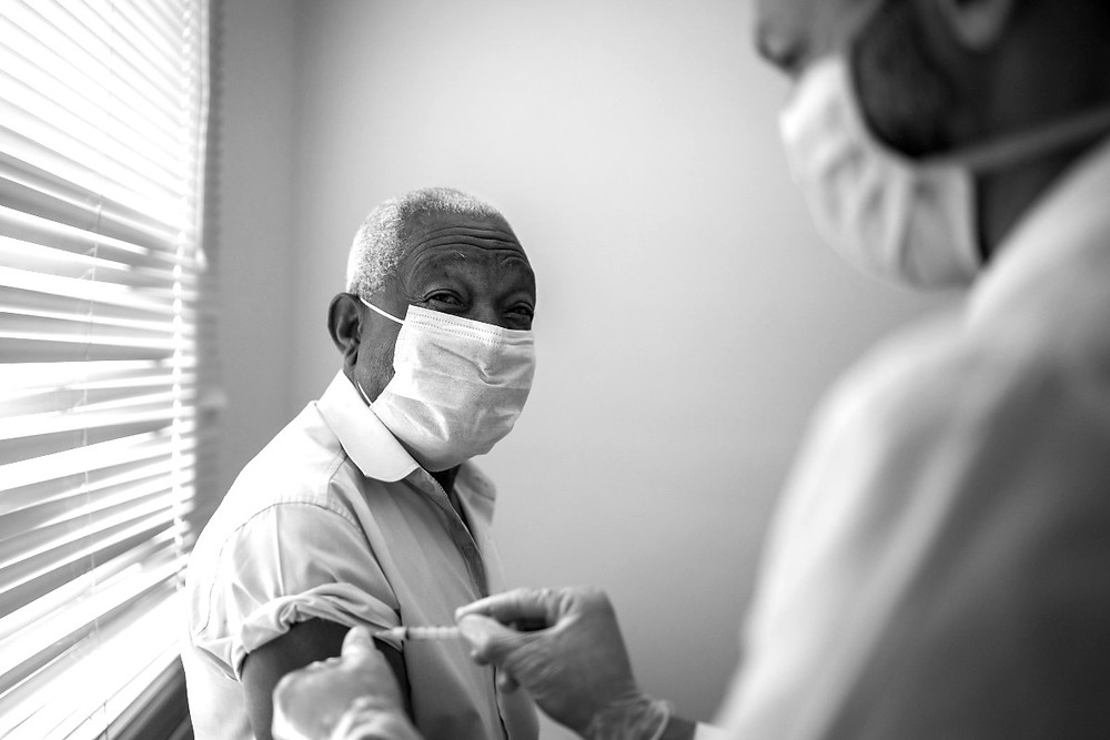 A black man receives a vaccination.