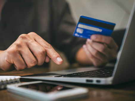 Person reviewing UK credit card options on a smartphone and laptop
