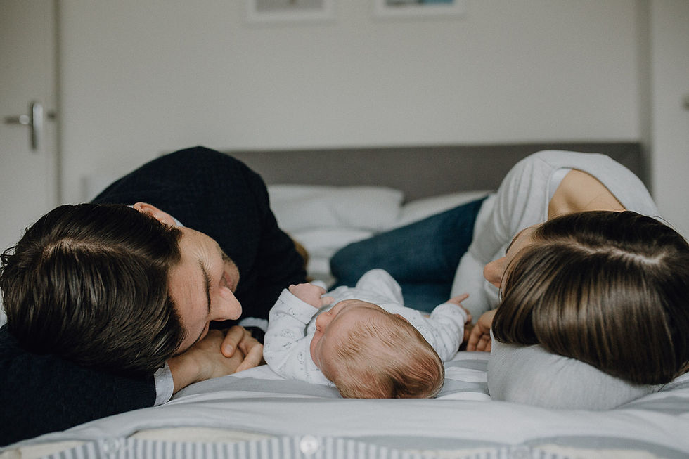Newborn with mum and dad lying on bed Frankfurt - Kristina Klinger Fotografie