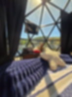 Interior view of a geodome project showcase with a bed.