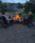 Couple sitting by a campfire at a geodome project showcase