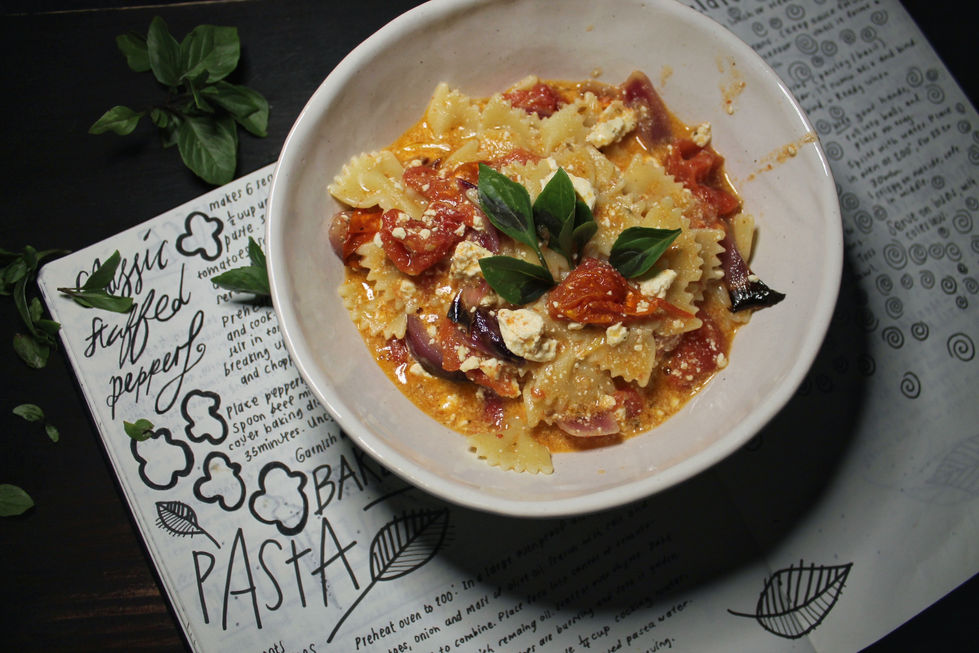 Home styled food photography of a bowl of tomato pasta with the handwritten recipe