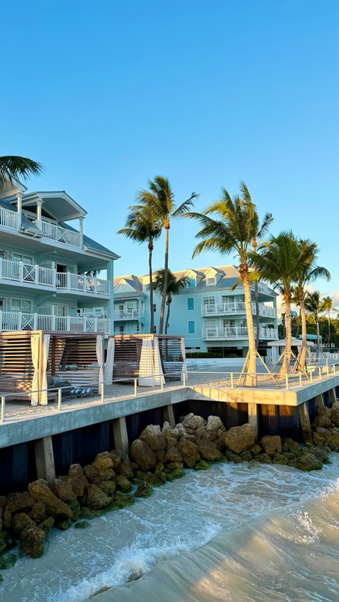 Waterfront view of Southernmost Beach Resort in Key West with tropical landscaping and ocean waves along the shoreline.