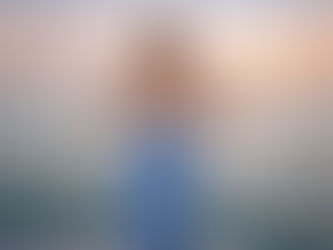 Woman standing on the Key West Express at sunset overlooking the ocean while wearing a blue floral skirt and white top.