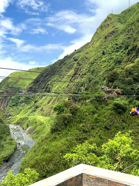 Ziplining over a lush green river valley at Mega Adventure Park Río Blanco in Ecuador