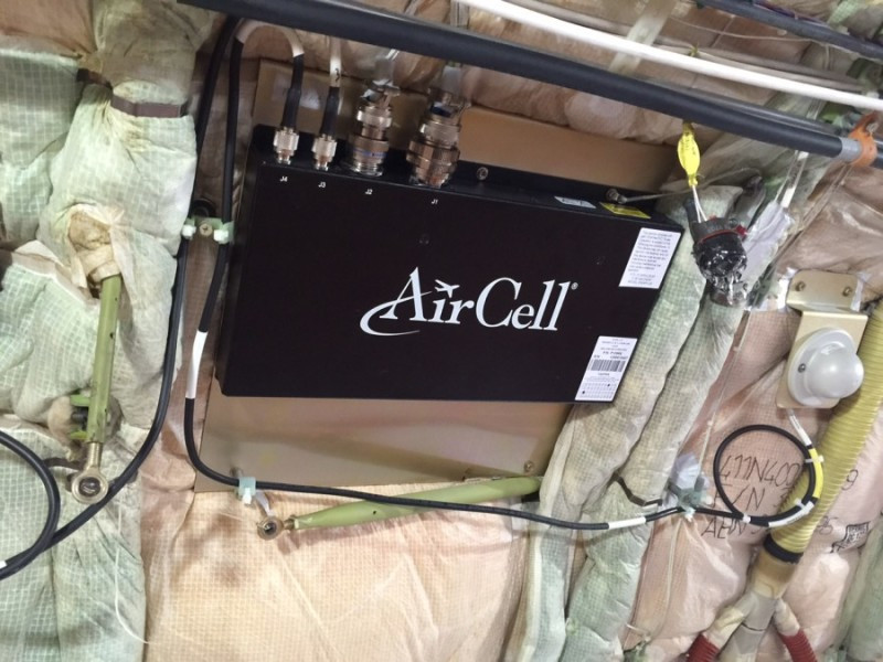 Black boxes called Wireless Access Points (or WAPs) line the interior of the starboard side of an airplane.