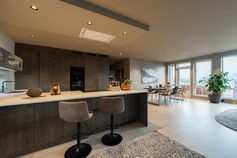 Kitchen and dining room in dark tones – real estate interior photo
