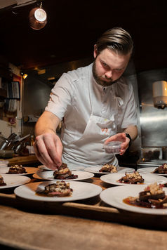 Chef plating food for guests – supper club photo