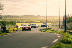 Convoy of cars on a country road at sunset – car photography
