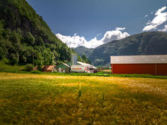 Farmstead with a red barn in a mountain landscape – drone photo