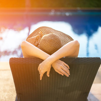 a woman looking at her pool thinking about selling her house