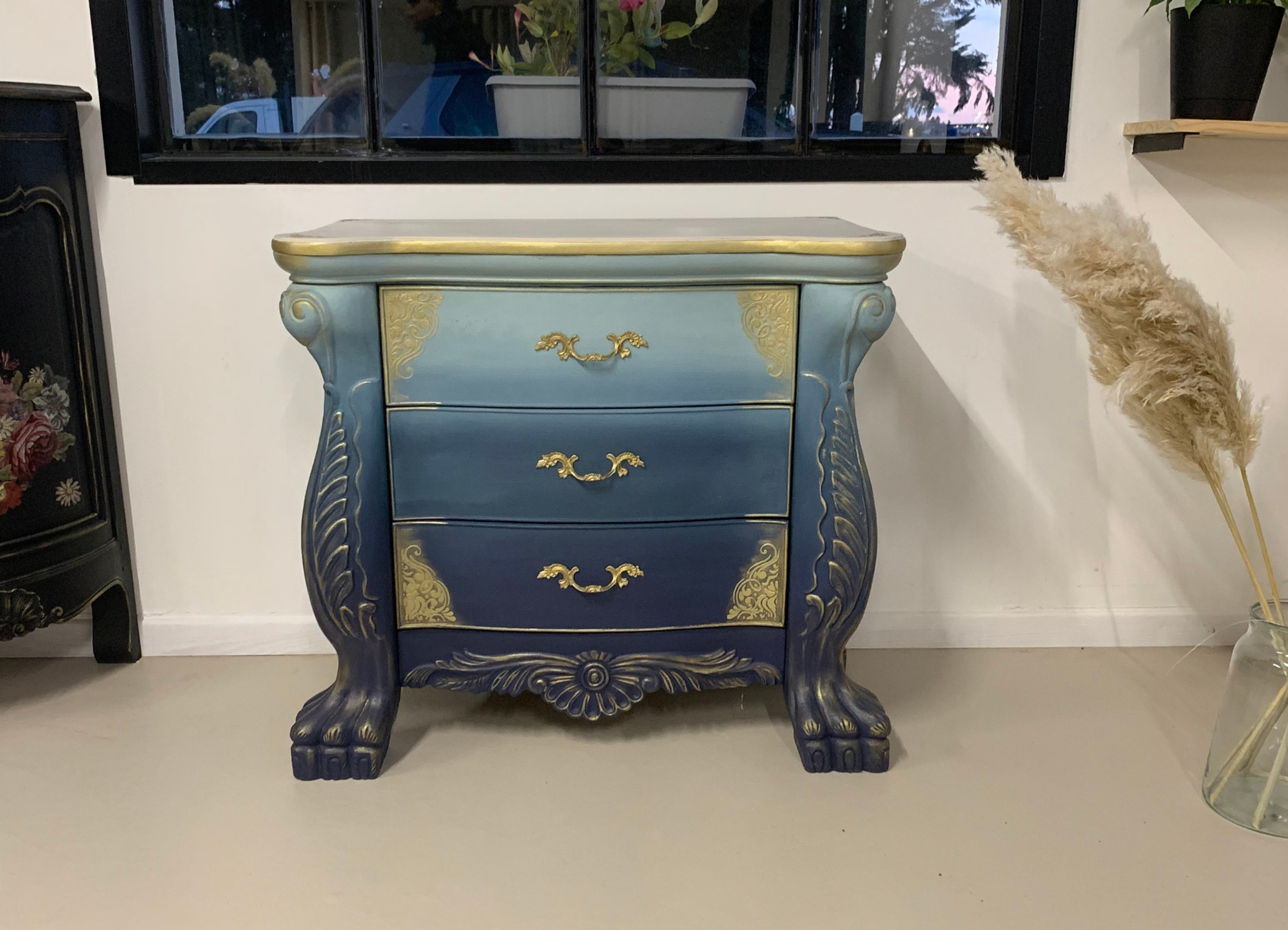 Création de meuble unique en bois massif. Une commode d'époque restaurée et décorée avec application d'ornements sur l'ensemble de la commode, l'intérieur et sur le plateau en bois massif et des ornements et poignées enduits de feuille dorée ainsi qu'une patine dorée réalisée sur l'ensemble du meuble pour un parfait relooking de meuble