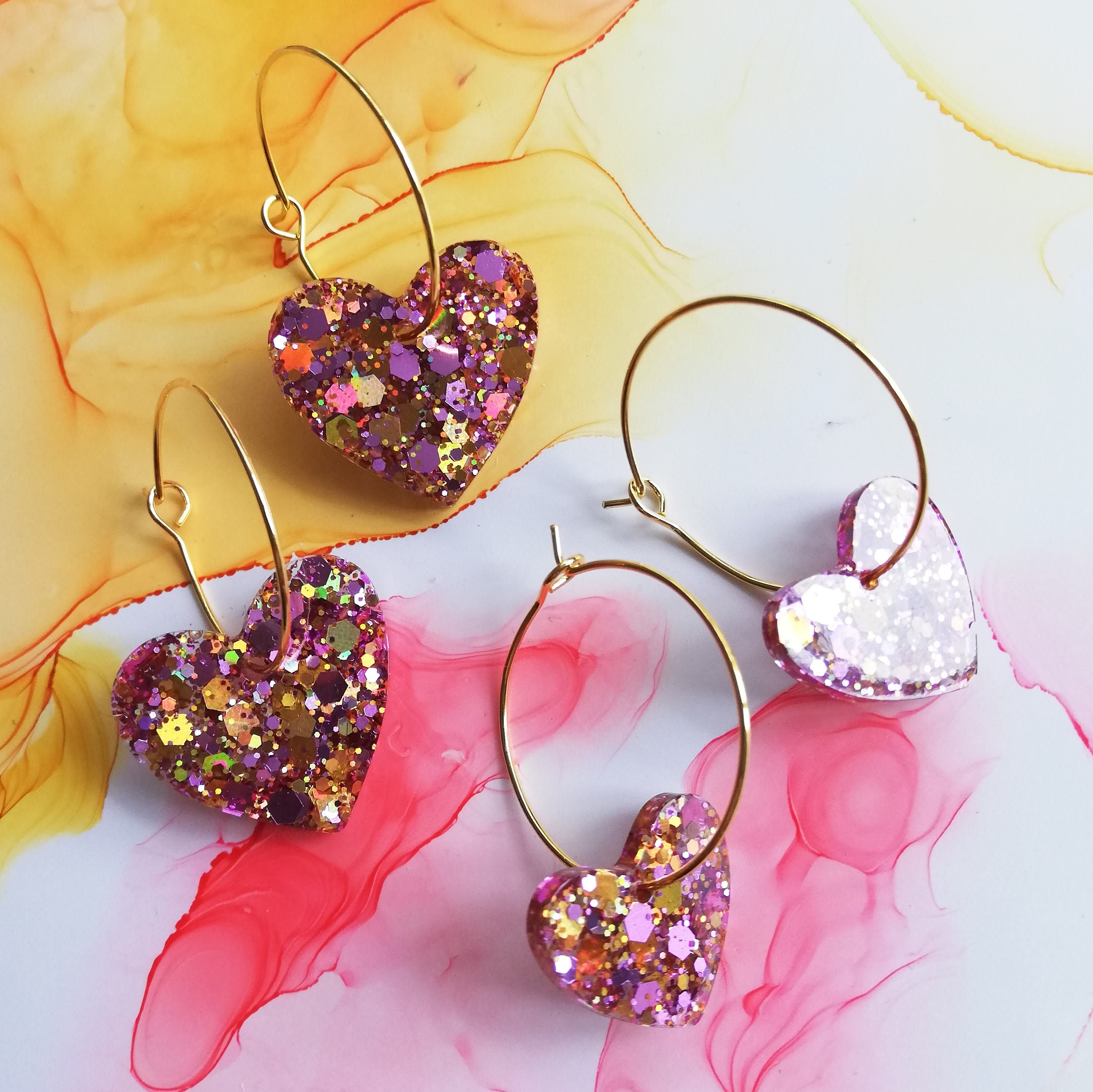 Handmade pink and gold glitter heart resin earrings on gold plated hoops