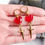 Thumbnail: Handmade resin red heart huggie hoops with stainless steel dagger