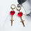Thumbnail: Handmade resin red heart huggie hoops with stainless steel dagger