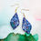 Thumbnail: Handmade Teardrop Dark Blue Glitter Christmas Earrings With Doves And Holly