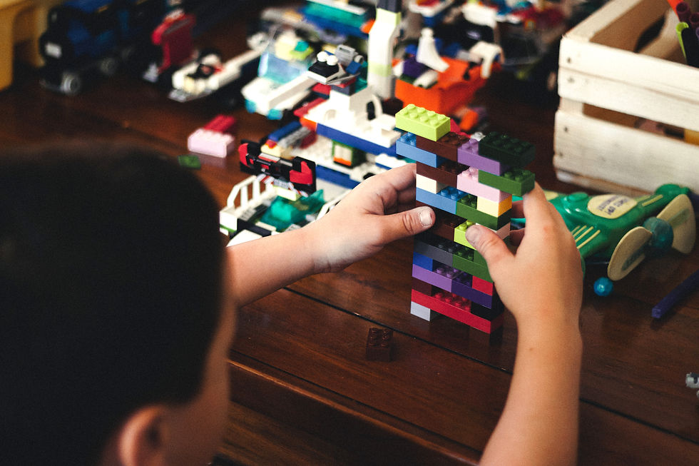 A child pieces together colorful LEGO pieces