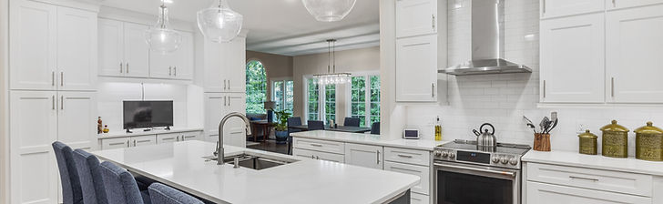 This award-winning Henrico kitchen remodel completely transformed a constrained layout into a breathtaking open concept space by removing an obtrusive peninsula and divider wall. The stunning redesign features crisp white perimeter cabinetry paired with a striking Wellborn Bishop Bleu island and luxurious Silestone Eternal Calacatta Gold countertops.