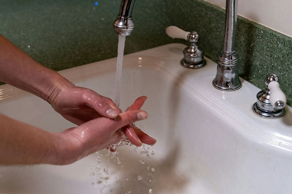 A girl washing her hands in the sink.