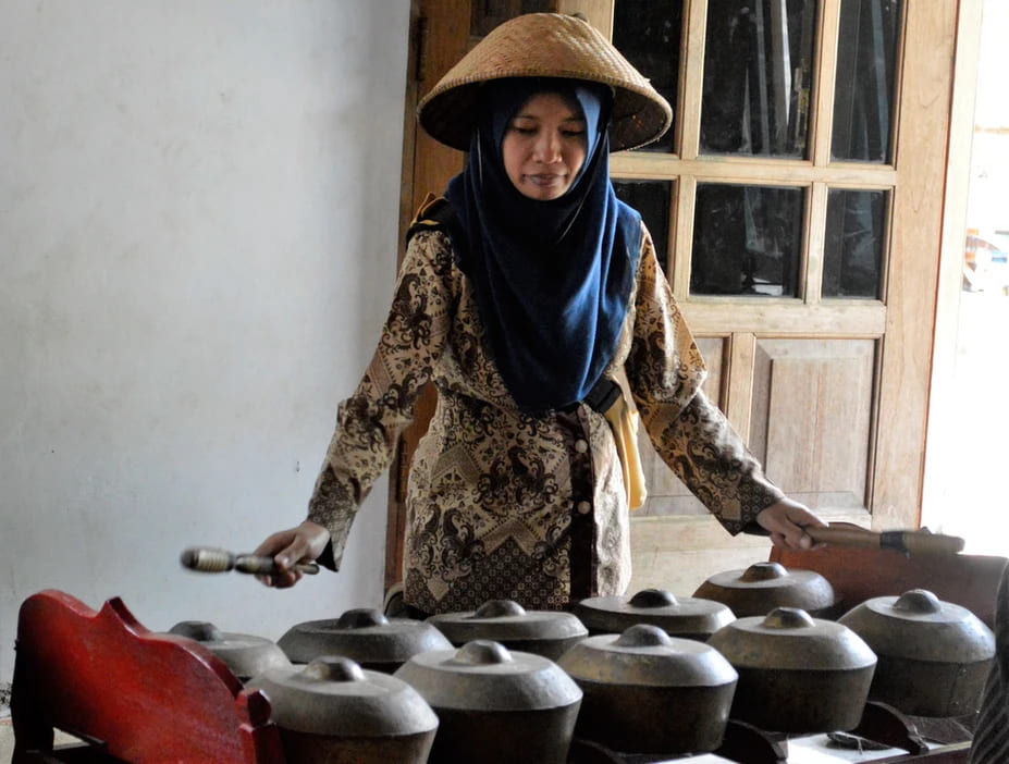 Foto di una donna vicino ad un gruppo di vasi posizionati su un tavolo