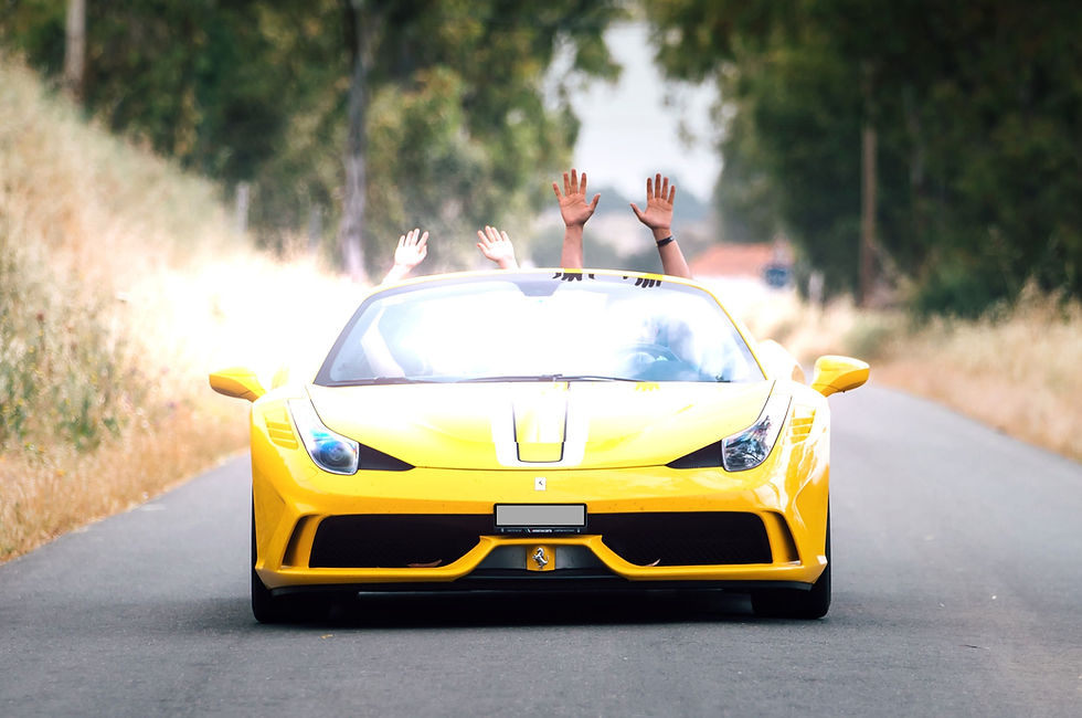 happy couple driving in a Ferrari convertible in Tuscany