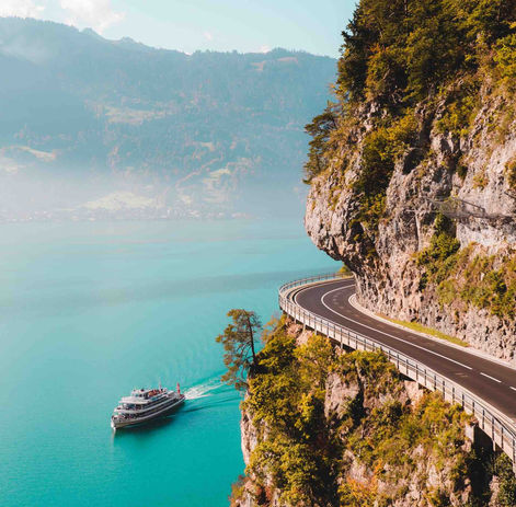 Famous cliffside lakeside road near Interlaken, carved into the rock high above turquoise water.