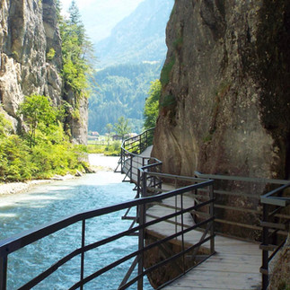 Walkway through the narrow Aare Gorge, clinging to rock walls above the turquoise Aare River.