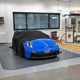 Blue Porsche 911 GT3 fully unveiled in the delivery bay, ready to start a Porsche European Delivery road trip.