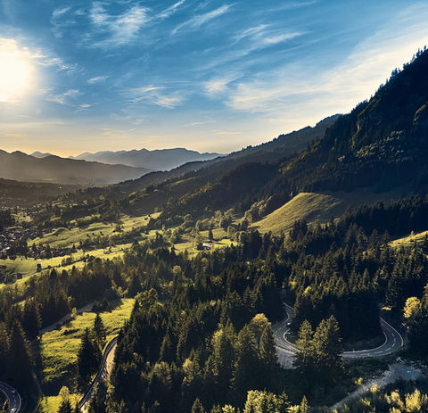 Aerial view of the Oberjoch Pass near Bad Hindelang in Bavaria, featuring winding alpine roads, green valleys, and mountain scenery along the German Alpine Road.