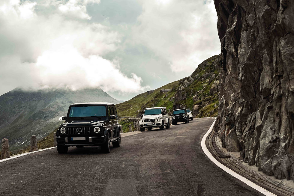 convoy of luxury mercedes amg suv on scenic alpine road in switzerland