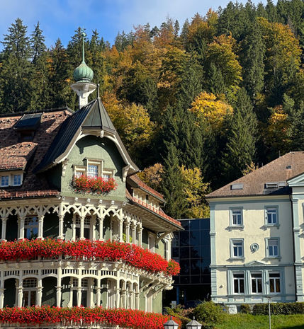 Historic Black Forest-style hotel in St. Blasien with ornate balconies covered in red flowers.