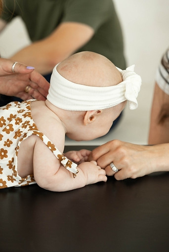 Baby receiving gentle pediatric chiropractic adjustment with parents at Soma Chiropractic Delray Beach and Boca Raton