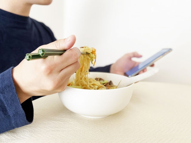 食事をしながらスマホを見る写真