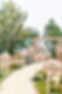 Outdoor wedding ceremony with floral decorations and a rose petal aisle WEDDINGS.