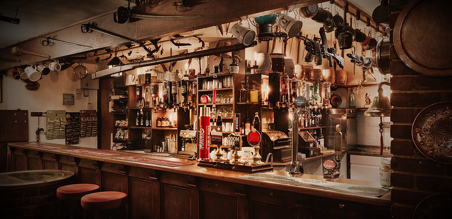 A photo of the bar in The Exeter Inn community pub, showing the various optics, pumps and bottles