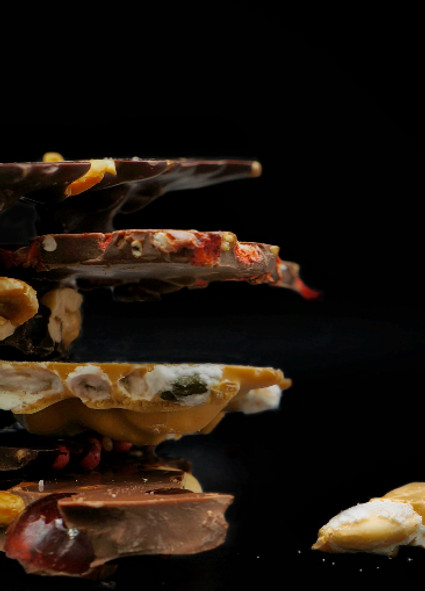 des éclats de chocolats noir lait et blonds garnis d'amandes, de noisettes de fraises 