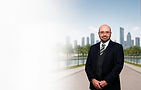 Jordan in suit and tie before city skyline