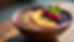Eye-level view of a colorful açaí bowl topped with fresh fruits and granola on a wooden table