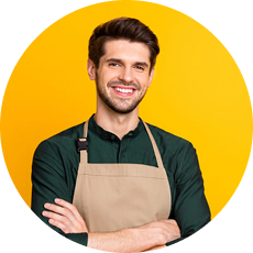 Smiling man wearing a shirt and apron against a yellow background