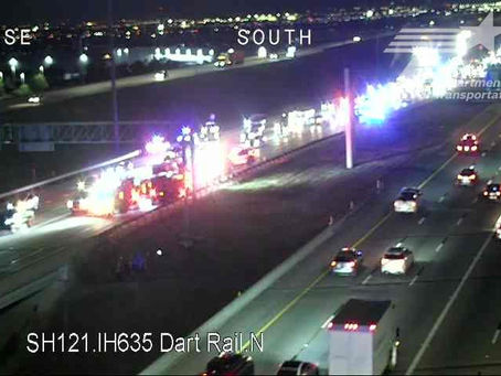 TxDOT traffic camera view of SH 121 near I-635 in Grapevine showing emergency vehicles with flashing lights along the median early Friday morning