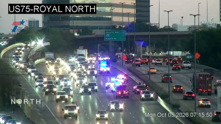 TxDOT traffic camera view of southbound US 75 near Royal Lane in Dallas showing emergency vehicles with lights on and backed-up traffic Monday morning Oct 5 2026