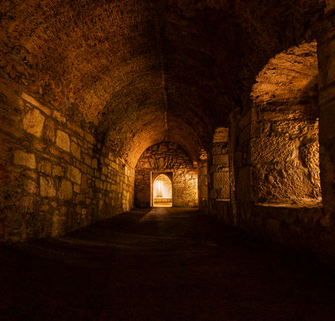 A dark hallway leads to a glowing doorway.