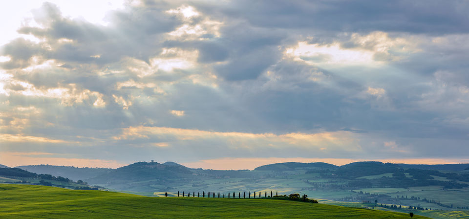 Sun streams through the clouds over Tuscany.
