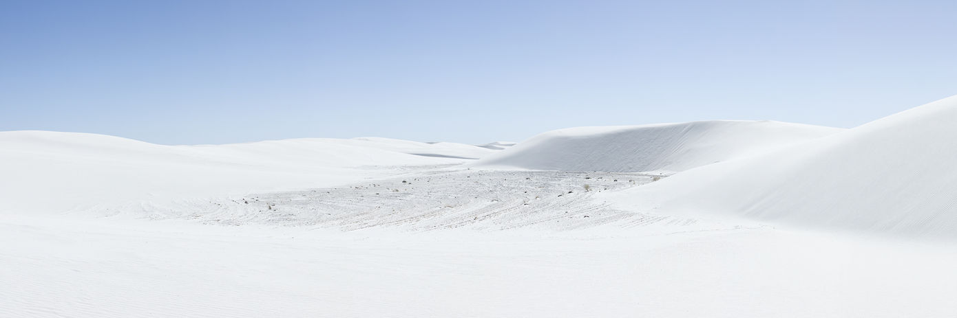 White sand dunes under a blue sky.