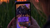 woman holding a cell phone. Romance book cover in the screen.