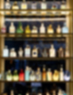 Backlit display shelves highlighting colorful ceramic bottles at Suelo Paris, lighting design.